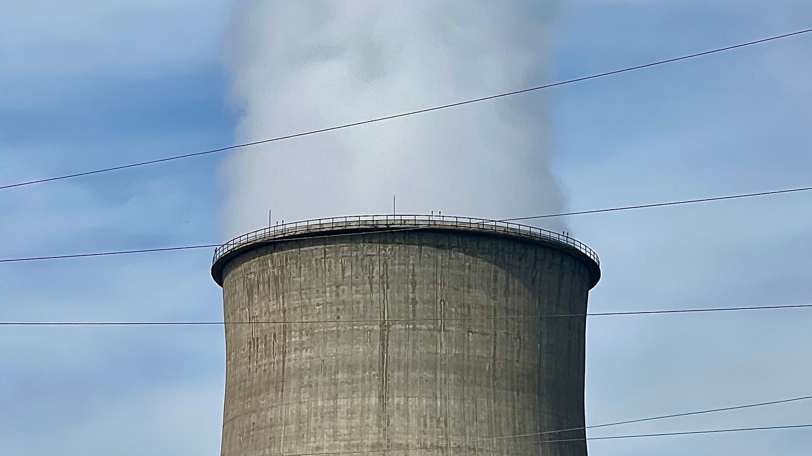 Torre de enfriamiento de una central eléctrica que libera vapor bajo un cielo despejado.